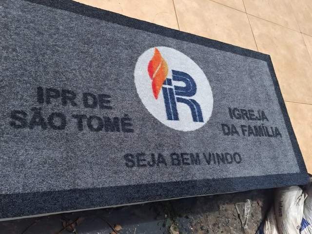 Tapete Cleankap cinza da IPR de São Tomé, Igreja da Família, com logotipo e a frase Seja Bem Vindo